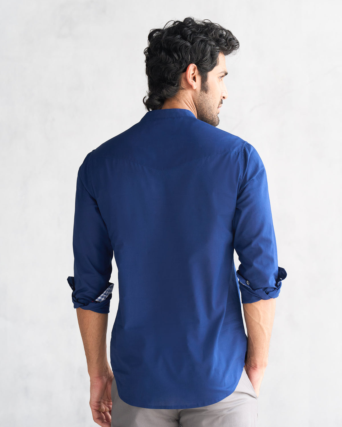 Back of a blue Pondicherry shirt worn by a person, showing the yoke.