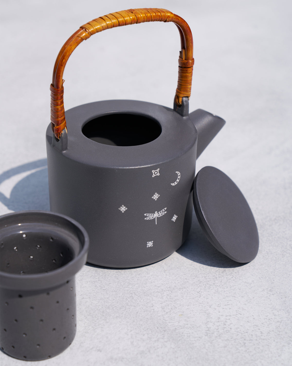 Taramandal teapot with lid aside and matching ceramic tea infuser.
