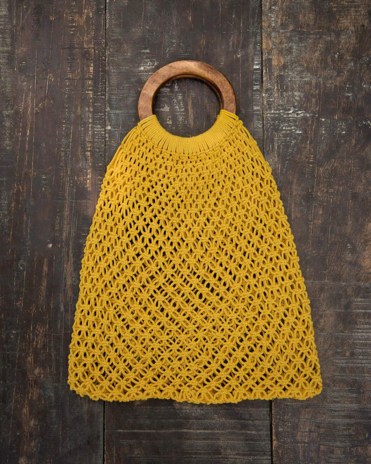 Mandovi Bag laid flat on wood, with its wooden ring handle at the top.