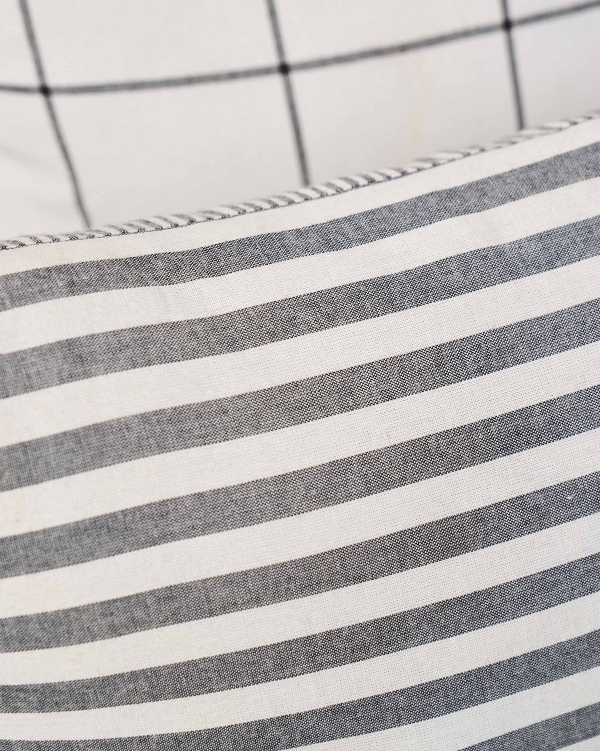Close-up of Black & White cushion cover showing a piped edge and stripes.