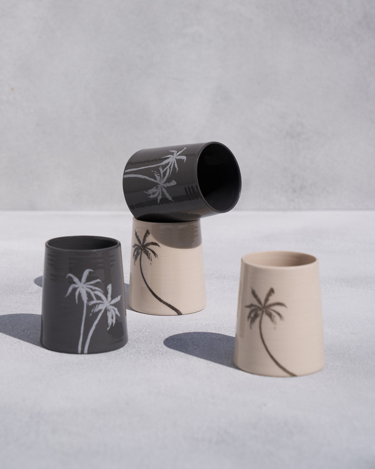 Swaying Palm Kulhars in cream and charcoal with palm tree motifs.