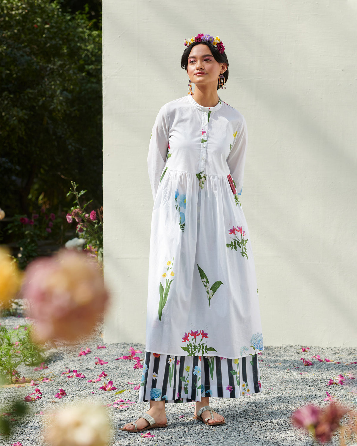Person wearing a white pleat-front kurta with floral prints and a gathered waist.