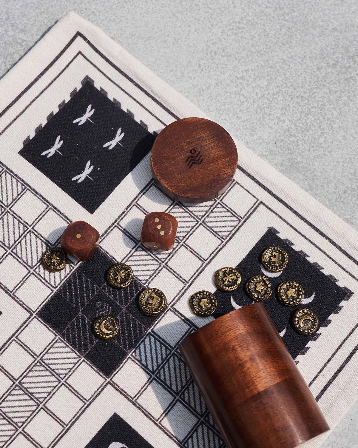 Nico Ludo wooden dice case and embossed brass tokens on the cloth board.