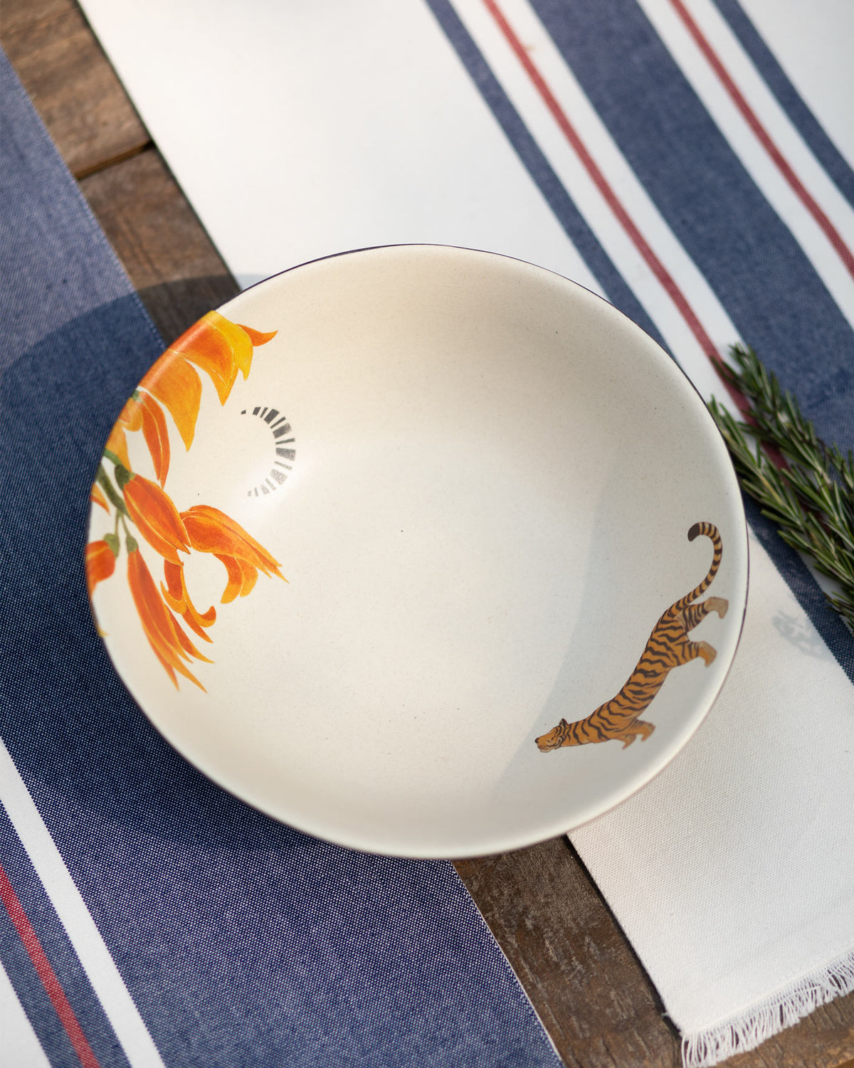 Cream Nadi curry bowl with tiger and orange flower prints inside.