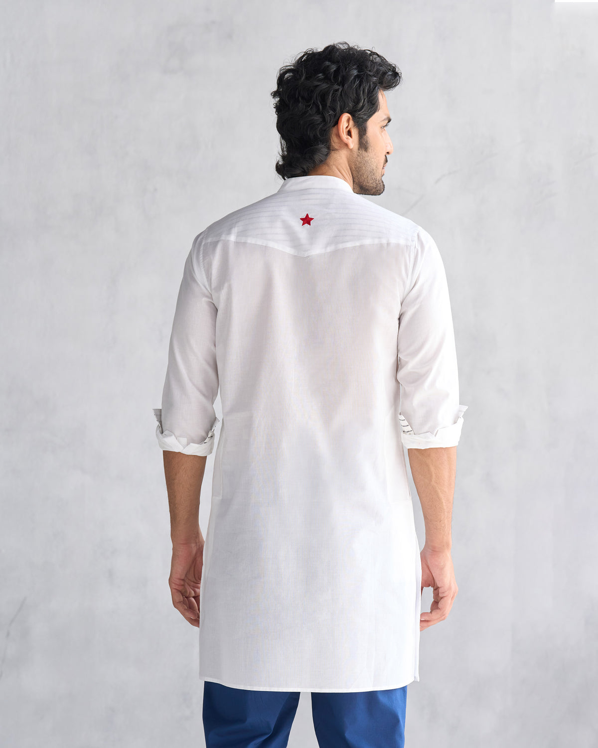 Back of a white Pondicherry Kurta with a red star on the yoke.
