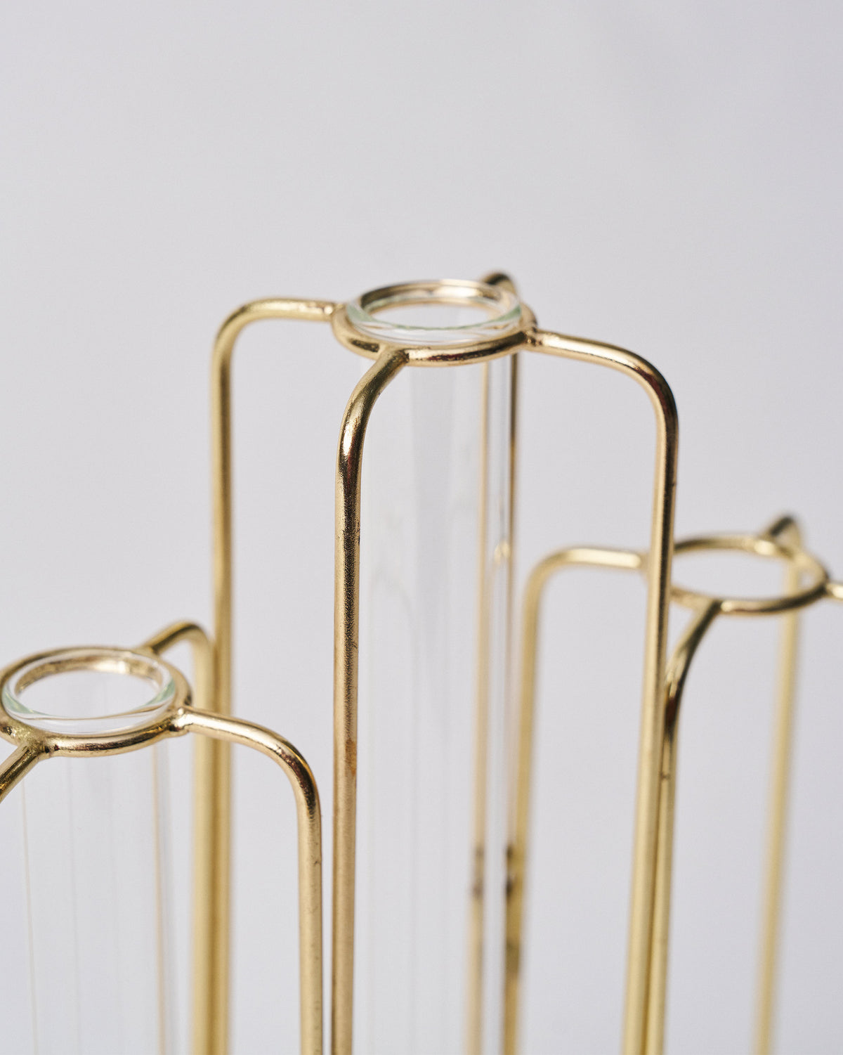 Close-up of glass tube tops set in gold wire holders.