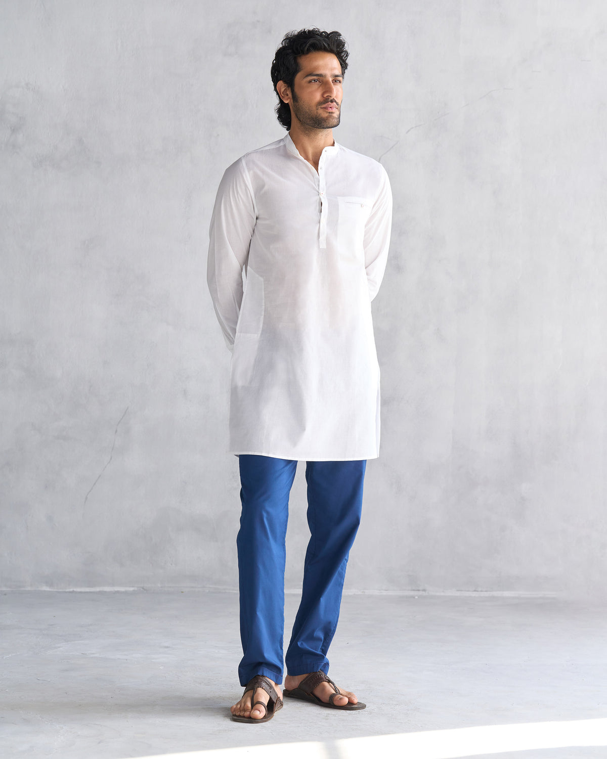 Person wearing a white Pondicherry Kurta with side slits and a chest pocket.