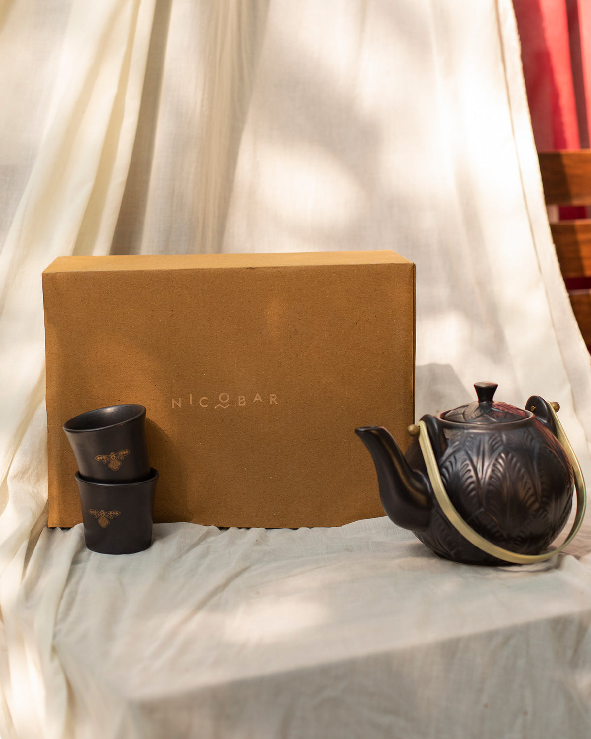 Moor teapot and cups in front of a Nicobar gift box.