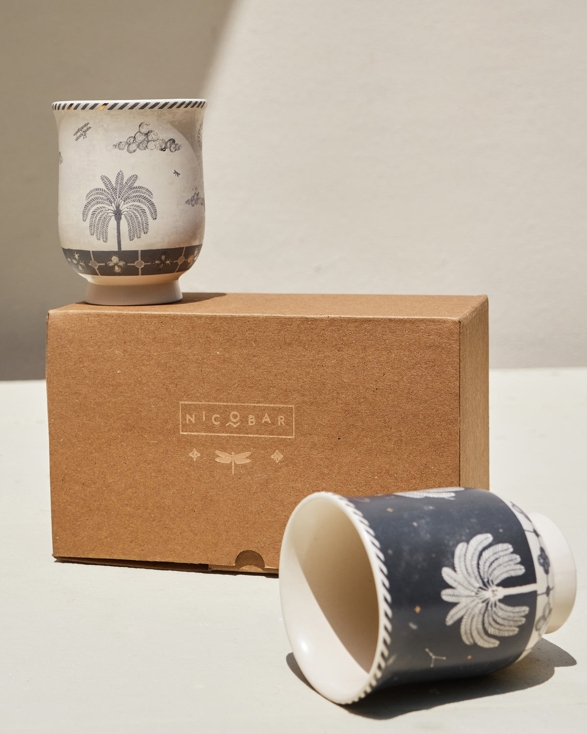 Twilight Tea Cups on a kraft Nicobar box, one cream and one navy.