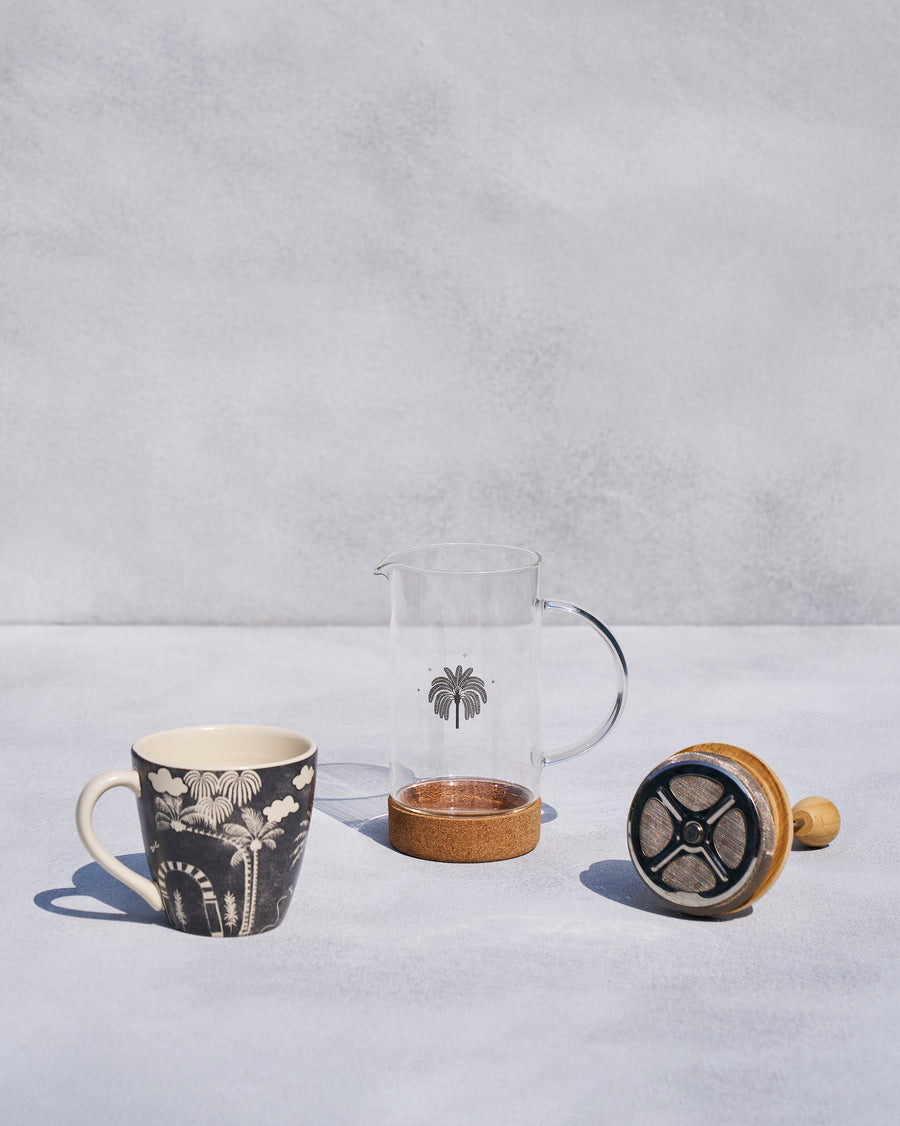 The French press parts and plunger beside the mug.